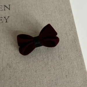 Elegant deep red velvet bow hair clip with vintage aesthetic and classic texture
