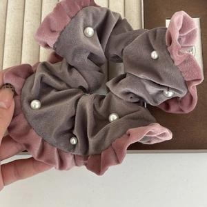 Détail d'un chouchou en velours gris avec volant rose et perles blanches nacrées