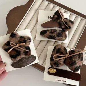 Detail view of handmade leopard print plush hair clips set in a velvet jewelry tray