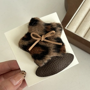 Star-shaped leopard print hair clip with bow accent and brown leather backing detail