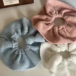 Knitted mohair scrunchies in blue, pink, and white with a soft fluffy texture