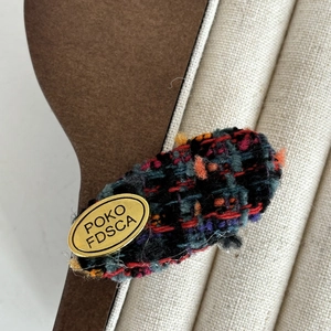 French tweed hair clip with gold metal plate and colorful wool fabric texture