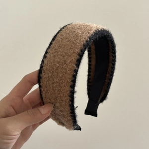 Detail of plush cream and black contrast headband with soft faux fur texture