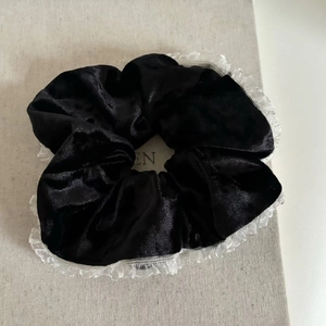 Elegant black velvet scrunchie with white lace edges for a French vintage hair style