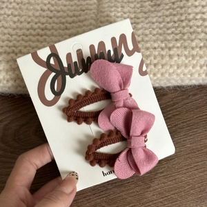Detailed macro view of pink and brown bow hair clips on a Sunny display card