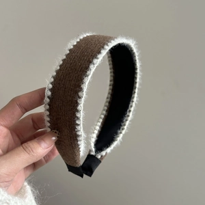 Detailed view of a brown knitted headband with soft white plush faux fur trim detail