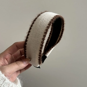 Detailed view of cream knitted headband with brown faux fur trim and non-slip lining