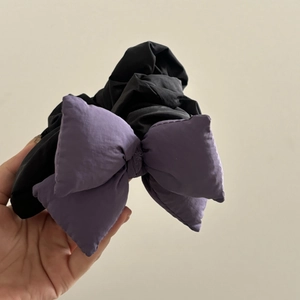 Large purple puffy bow hair scrunchie held in hand for a sweet Japanese style aesthetic