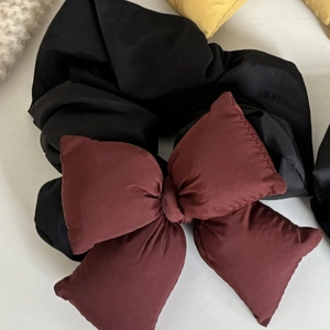 Close-up of a large burgundy padded bow hair scrunchie with black matte fabric detail