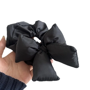 Black puffy padded bow scrunchie made of shiny fabric for high ponytail styling