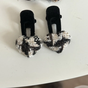Close-up of heart-shaped tweed hair clips with black velvet lining in a set of two