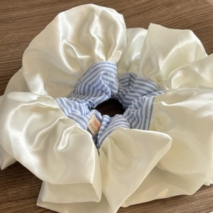 Detailed macro view of cream lace scrunchie with blue stripes and Hand Made tag