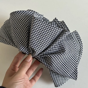 Large black and white gingham checkered hair accessory with structured layered ruffles