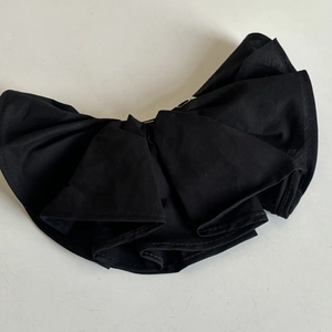 Detail of multi-layered black ruffled fabric bow with precise stitching for hair accessories