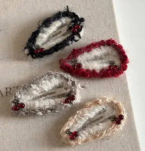Detailed macro of handmade knit cherry hair clips with red pearls on vintage book