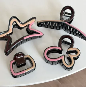 Detail of four retro style hair claws in star, butterfly, and geometric wave patterns
