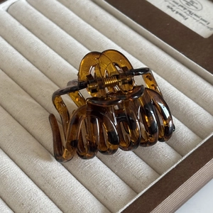 Detailed view of leopard print hair claw clip showing glossy resin and gold metal spring