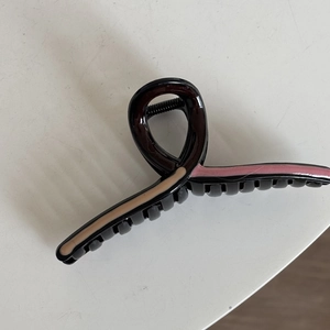 Detail view of wavy contrast color hair claw clip with khaki and pink panels