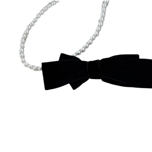 Elegant black velvet bow hair clip with white pearl chain for a vintage French hairstyle