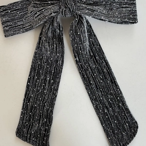 Detailed macro view of the black and silver bow hair clip with shimmering rhinestones