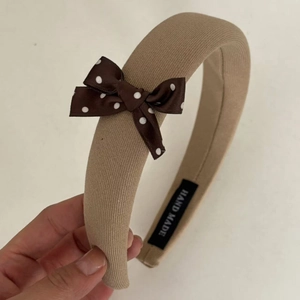 Handmade brown polka dot bow headband featuring wide fabric strap and vintage style
