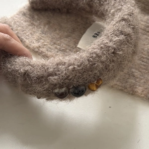 Vue macro d'un serre-tête en peluche marron avec des perles en résine en forme de cœur