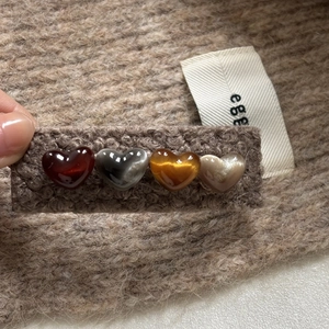 Vue détaillée d'une barrette en peluche avec quatre perles de résine en forme de cœur