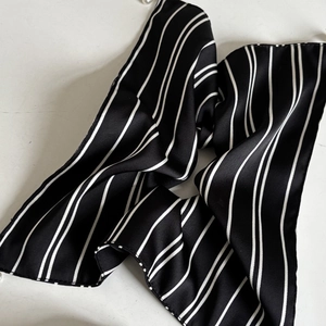 Eleganter Haargummi mit schwarz-weißen Streifen und glänzender Satin-Oberfläche