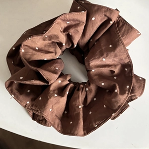 Brown polka dot scrunchie made of smooth woven fabric for elegant ponytail hair styling