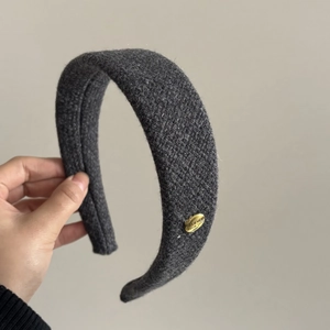 Dark grey tweed padded headband featuring a golden metallic logo tag with motivational text