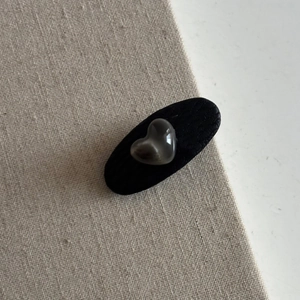 Detailed close-up of the elegant black faux leather BB clip with a grey resin heart charm