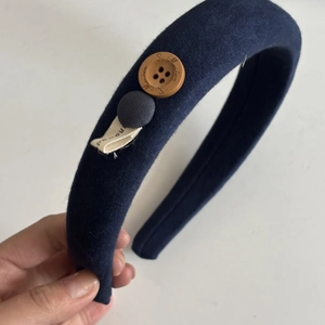 Detail of navy blue matte velvet headband with vintage buttons and handmade label