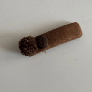 Plush brown button hair clip with soft fuzzy texture and cute round decorative balls