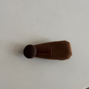 Close-up of brown plush hair clip with sweet love tag and coffee fabric button