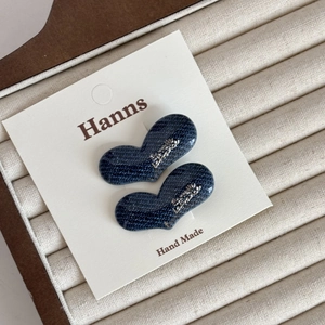 Boucles d'oreilles cœur en denim avec lettres argentées sur carte de présentation