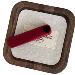 Elegant deep red silk barrette featuring a black velvet heart on a vintage wooden tray