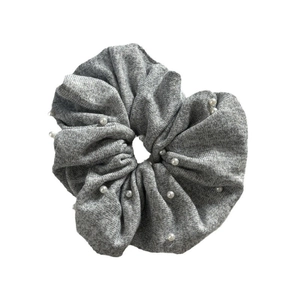 Chouchou en tricot gris avec perles blanches décoratives sur fond blanc épuré