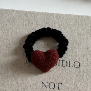 Elegant red knit heart hair clip with golden tag on premium black textured fabric base