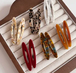 Close-up of assorted tortoiseshell and marble acetate hair clips on velvet tray