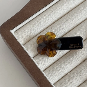 French style tortoiseshell flower hair clip with handmade gold lettering on a black base