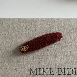 Elegant brick red wool hair clip with golden Korea label and soft teddy fleece texture