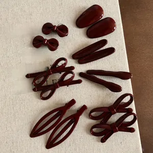 Gros plan détaillé de barrettes à cheveux vintage rouge foncé aux formes géométriques
