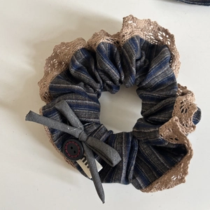 Détail du chouchou rayé bleu marine avec dentelle au crochet et bouton décoratif