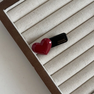 Detailed macro view of a red heart-shaped hair clip with gold France handmade lettering