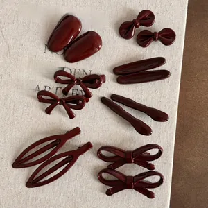 Vue à plat de pinces à cheveux nceud rouge foncé et barrettes en résine brillante