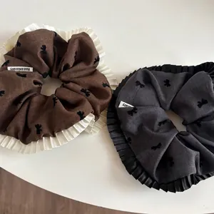 Caramel brown and charcoal grey pleated scrunchies with bow print and lace trim