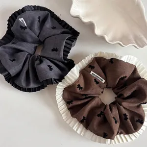 Two-piece set of caramel bow scrunchies with pleated lace and have a nice day labels