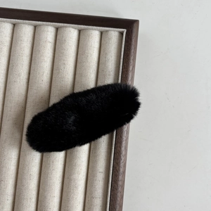 Barrette à cheveux minimaliste en peluche noire en fausse fourrure douce sur présentoir