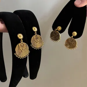Vintage style round bronze earrings with embossed wavy texture and tassel details