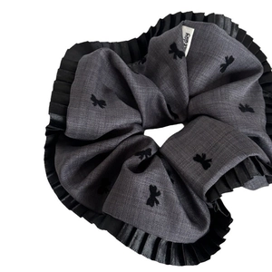 Dark grey bow print scrunchie with black pleated lace edges and 'nice day' label